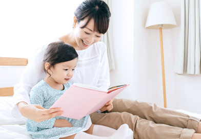 子供に本を読んであげているお母さん